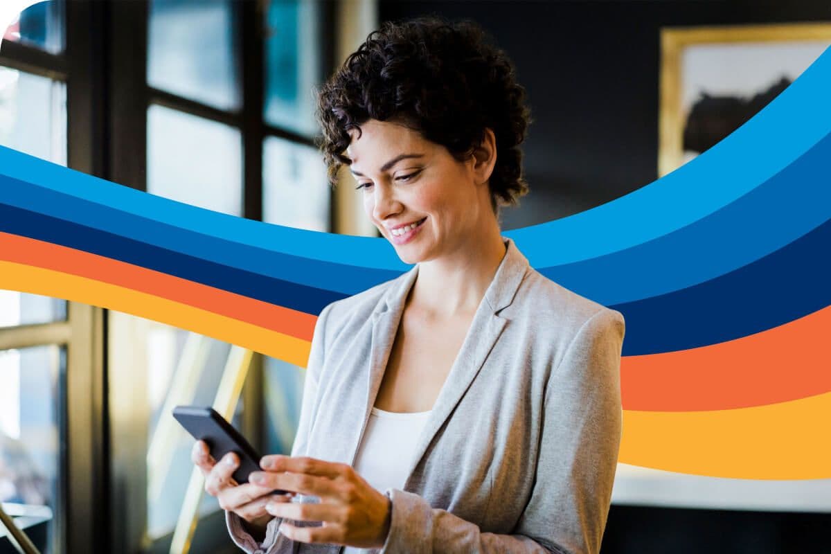 a woman is smiling while looking at her cell phone